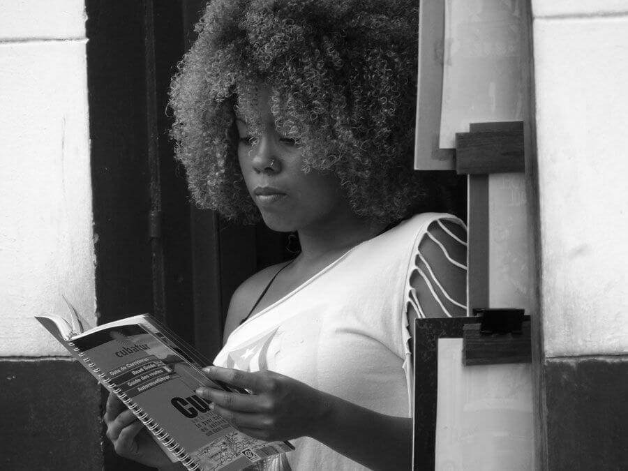mujer cubaba leyendo fuera de su negocio